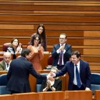 El presidente de la Junta Alfonso Fernández Mañueco felicita al consejero de Economía Carlos Fernández Carriedo tras la aprobación del techo de gasto en el Pleno de las Cortes.