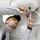 Un fontanero autónomo arregla un calentador de agua.