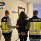 Dos agentes de la Policía Nacional deteniendo a una persona.