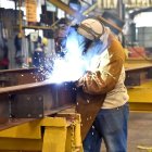 Un operario suelda una estructura en una industria metalúrgica.
