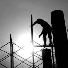 Un operario de la construcción trabaja subido a un andamio.