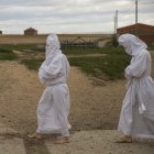 Unos penitentes en la Procesión de La Carrera en Villarrín de Campos (Zamora), al fondo unos palomares.