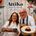 Julia y Rafael presentan dos opciones de la carta. La tabla de de presa iIbérica con pimientos y patatas fritas y un plato de arroz negro con langostinos.