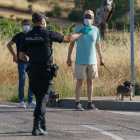 Un policía se dirige a un hombre que pasea a sus perros en el primer día de confinamiento de la localidad de Aranda de Duero (Burgos). - CESAR MANSO / AFP