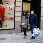 Dos personas pasan por delante de un comercio de moda en el centro de Valladolid. - J. M. LOSTAU
