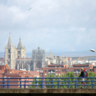 Una peregrina llega a la ciudad de León con su Catedral fondo en una imagen pasada.- ICAL