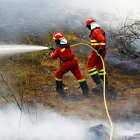 Dos efectivos de la Junta tratan se sofocar un incendio en Ávila. E. M.