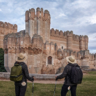 Dos peregrinos contemplan el castillo de la localidad segoviana de Coca.- PRODESTUR SEGOVIA