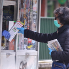 Una mujer compra la prensa durante el Estado de alarma por el coronavirus. - ICAL