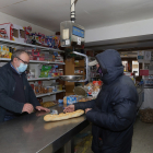 Un cliente compra pan en una tienda de alimentos y productos de primera necesidad en Amusco (Palencia). ICAL