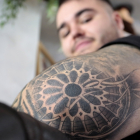 El DJ Eric García, muestra el tatuaje del rosetón de la Catedral de León que le realizaron en All Street Barber & Tattoo Studio de la capital leonesa.- ICAL