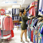 Una joven formada con los proyectos de La Caixa trabaja en una tienda de ropa.- ICAL