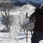 Un hombre retira la nieve con una pala en la montaña de León. / ICAL.