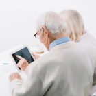 Dos personas mayores consultan información en una tableta. - FREEPIX