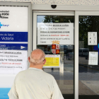Un señor mira los carteles indicativos en la entrada de un centro de salud del barrio de La Victoria, en Valladolid. - ICAL