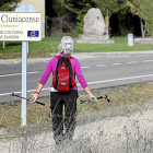 Una peregrina mira un cartel identificativo del Camino de Santiago en Carrión de los Condes (Palencia).- ICAL