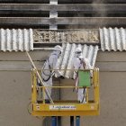 Dos trabajadores retiran placas de uralita con amianto en el tejado de una nave industrial de Valladolid. ical
