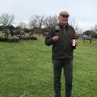 Ezequiel Pérez, con una botella de vino Ituero, en la dehesa, junto a una vacada de moruchas y una piara de cerdos ibérico.  / ARGICOMUNICACIÓN