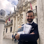 Víctor Cazurro Barahona sujeta sus dos últimos libros sobre la protección de datos frente a la fachada de la Facultad de Derecho de Valladolid../ ARGICOMUNICACIÓN