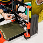 Dos personas manipulan una impresora 3D. J. M. LOSTAU