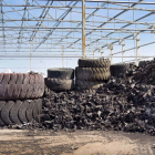 Close up of old used tires and shredded tire pile in background