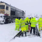 Operarios de Renfe y Adif trabajando para despejar de nieve una vía.