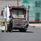 Un operario mueve un contenedor junto al camión de la basura. - D. M.