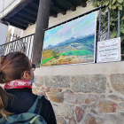 Una turista contempla uno de los cuadros que cuelgan de las calles de al localidad. / LA POSADA.