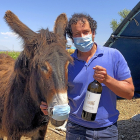 Richard y el burro Sobrenatural, ambos con mascarilla, con una botella de su Menade Verdejo Ecológico.  / ARGICOMUNICACIÓN