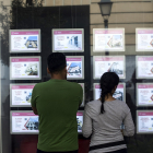 Una pareja de jóvenes ven anuncios de una inmobiliaria.-  JAVI MARTÍNEZ