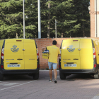 Un repartidor de Correos, en Palencia, se dispone a cargar una caja con cartas en un vehículo.