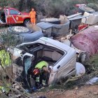 Los bomberos trabajan para excarcelar al conductor en el camión volcado en León