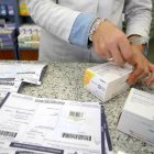 Una farmacéutica recorta el identificador del medicamento.-Ical