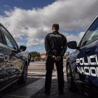 Imagen de archivo de un agente de la Policía Nacional junto a dos vehículos.