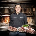 Felipe Giraldo posa ante su rincón favorito, el de la brasa, por el que pasa las carnes.