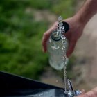Imagen de archivo de una persona llenando una botella de agua de una fuente.