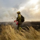 Un bombero trata de extinguir un incendio.