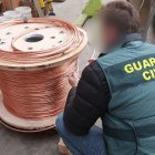 Agente de la Guardia Civil con un rollo de cobre intervenido.