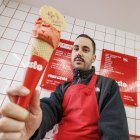 Jaime Carazo posa con uno de sus helados en el local que acondicionó con sus propias manos para cumplir un sueño. Los colores elegidos, blanco y rojo, homenajean a su maestro italiano.