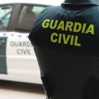 Un agente de la Guardia Civil junto a un vehículo oficial.