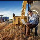 Un hombre utilizando su portatil en mitad del campo