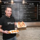 Alejandro Burgos muestra un plato con croquetas de huevo cocido y una bandeja con varias tapas de queso de cabra, mermelada y cebolla caramelizada.