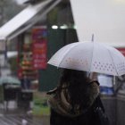 Una persona se protege de la lluvia en una imagen de archivo