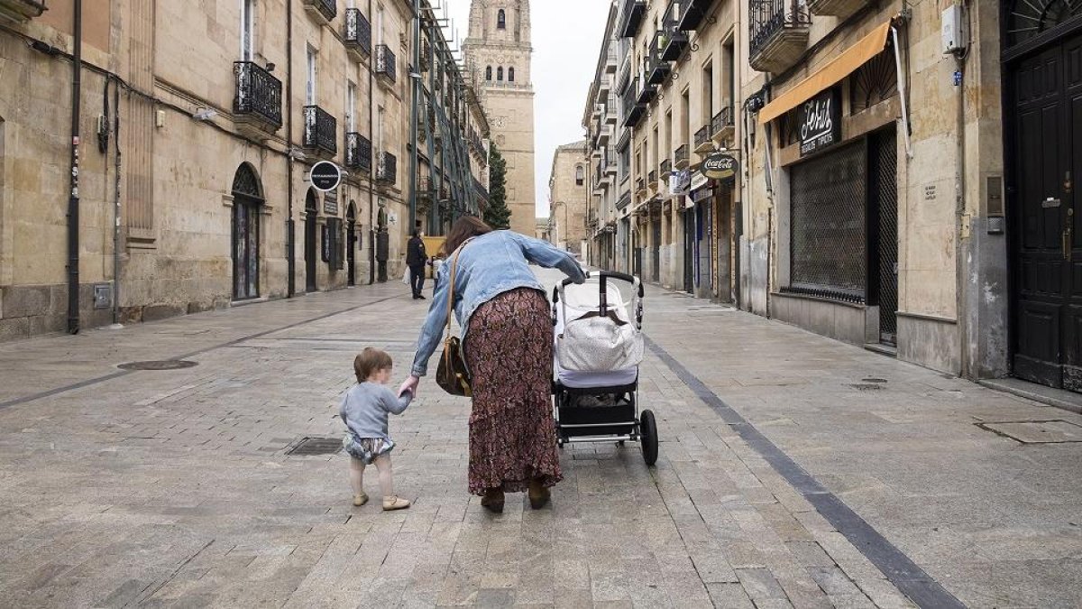 Una mujer pasea con su hijo pequeño por las calles de Salamanca, en una imagen de archivo.- ICAL