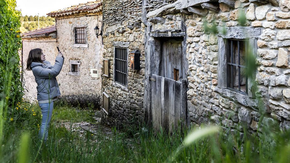 Una joven fotografía una casa de La Cuenca.