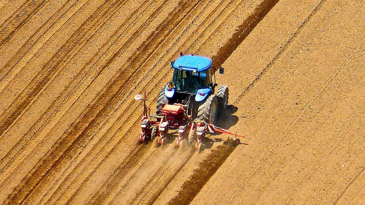 Un agricultor ara un campo de cultivo con su tractor para proceder a la sementera