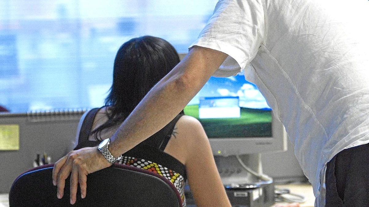 ACOSO LABORAL. ACOSO SEXUAL EN EL TRABAJO - BILBAO - PAIS VASCO.  UN HOMBRE Y UNA MUJER TRABAJAN EN UNA OFICINA. VERTICAL