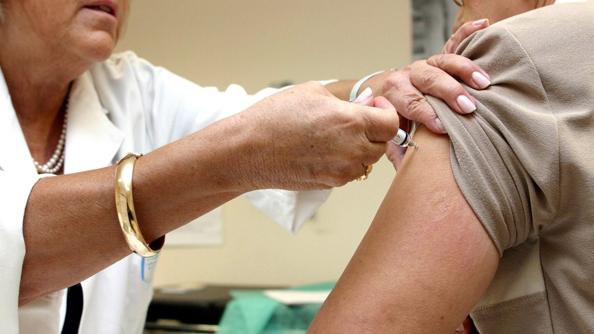 Una persona mayor se vacuna contra la gripe en su centro de salud