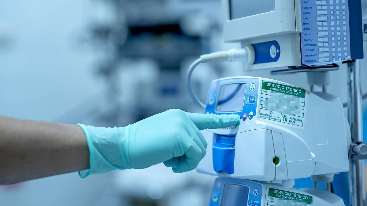 Un sanitario regula un monitor de signos vitales antes de una operación.