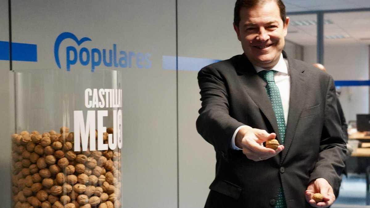 El presidente del PPCyL, Alfonso Fernández Mañueco, muestra unas nueces de su eslógan 'menos ruido y más nueces'.